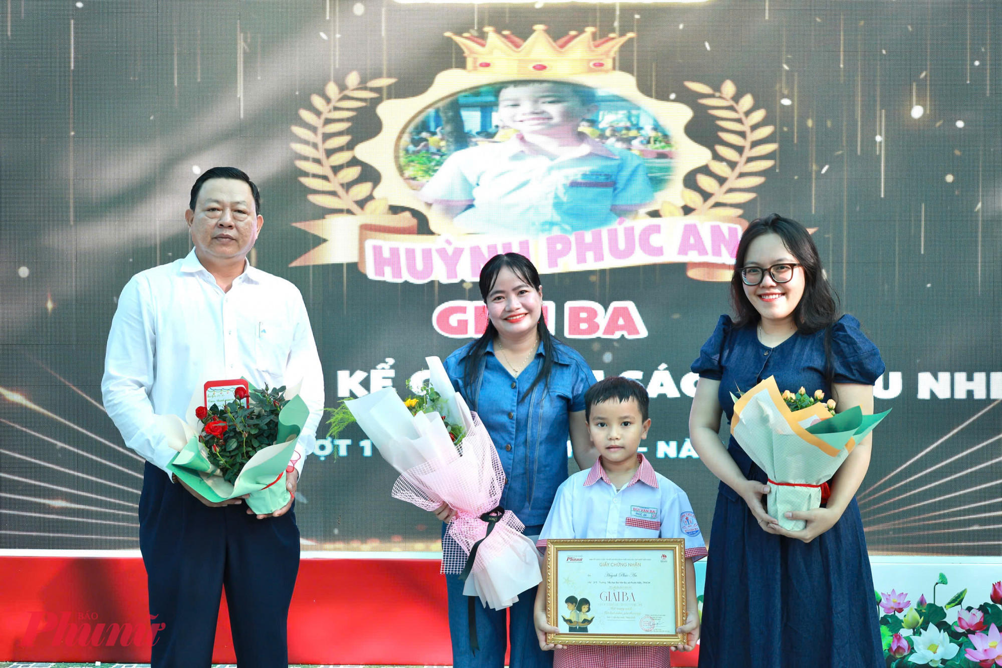 Đại diện Báo Phụ Nữ TPHCM và đại diện nhà trường trao giấy khen cho em Huỳnh Phúc An - Ảnh: Hồng Nga
