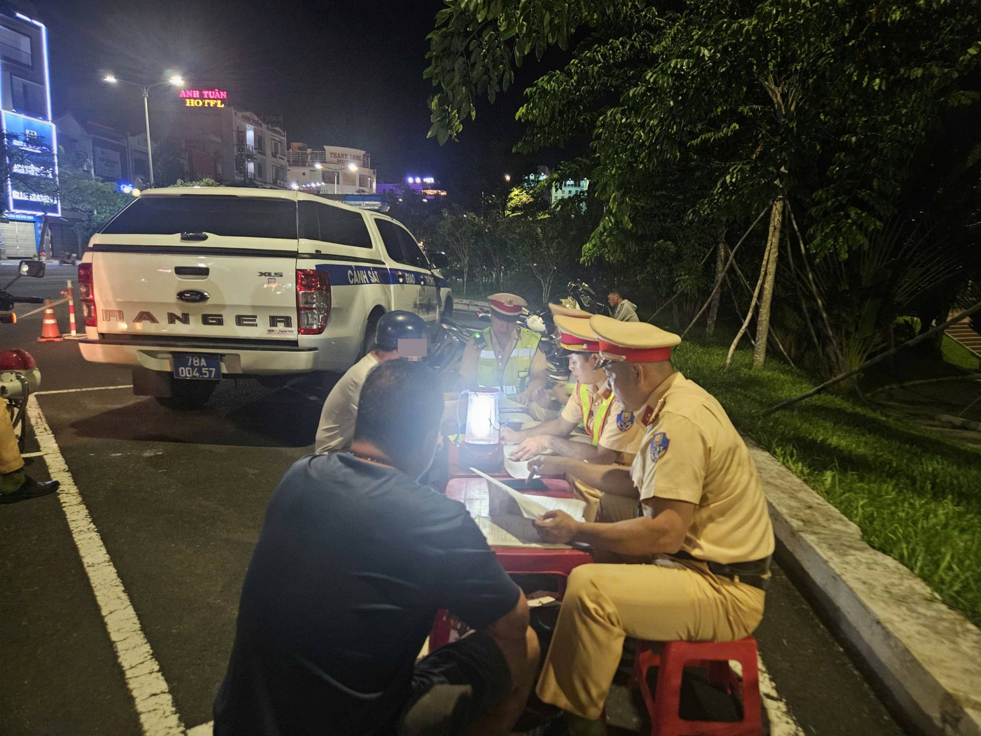 Anh P.C.N. (người đội nón sơn) làm việc với lực lượng công an - Ảnh: M.N.