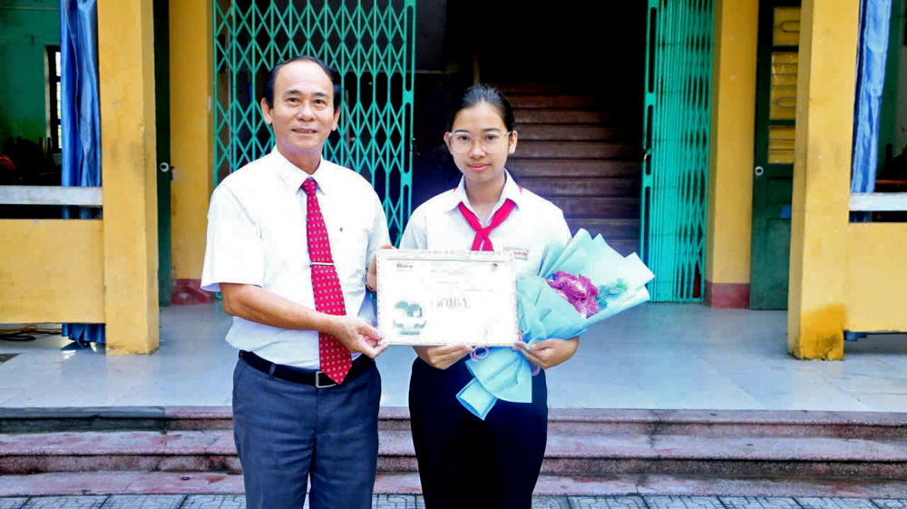 Gieo mầm tình yêu với sách Thầy Nguyễn Thìn - Hiệu trưởng Trường THCS Nguyễn Xuân Thưởng, TP Huế - trao giải Ba cho thí sinh Nguyễn Ngọc Hân - học sinh lớp 9/3 ẢNH: THUẬN HÓA