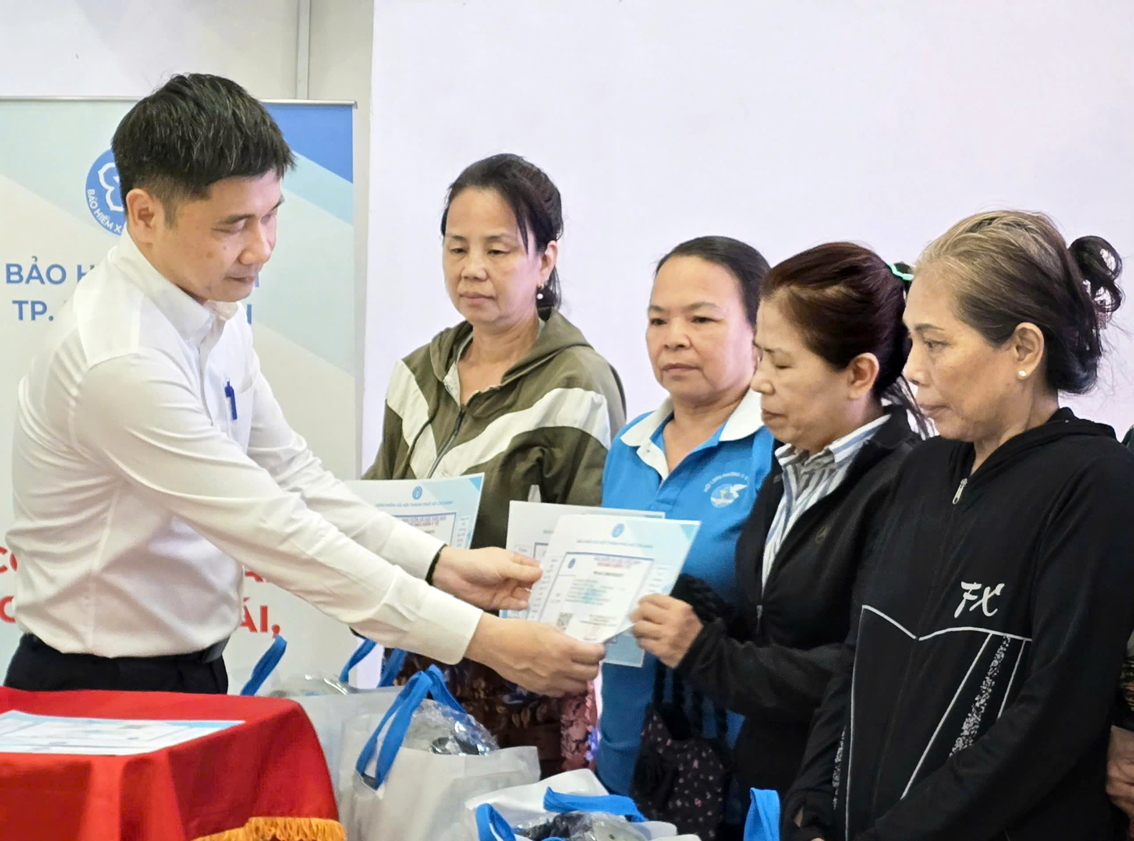 Ông Trần Dũng Hà - Phó giám đốc Bảo hiểm xã hội TPHCM - trao tặng thẻ bảo hiểm y tế cho hội viên phụ nữ có hoàn cảnh khó khăn