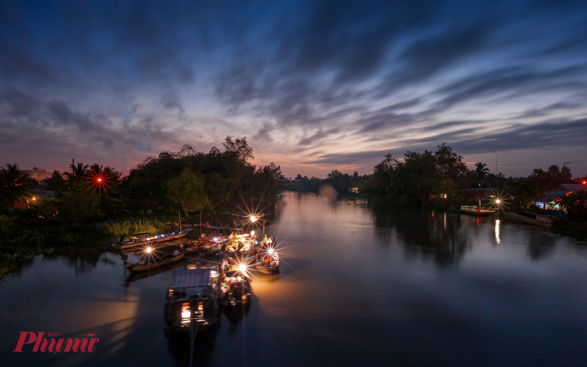 Những điều không nên bỏ qua khi du lịch miền Tây mùa này Hòa mình vào nhịp sống chợ nổi  Một chuyến đi mùa nước nổi sẽ chưa trọn vẹn nếu bạn chưa thử ghé các chợ nổi – nơi phác họa đậm nét văn hóa miền sông nước. Chợ nổi Cái Răng (Cần Thơ), Phong Điền hay Cà Mau từ lâu đã trở thành điểm đến quen thuộc của du khách. Giữa dòng sông tấp nập, những ghe thuyền chở đầy hàng hóa, trái cây tươi, tiếng rao lanh lảnh hòa cùng tiếng máy nổ giòn tan tạo nên một bức tranh sinh động. Chỉ cần gọi một ly cà phê đen, thưởng thức tô hủ tiếu nghi ngút khói ngay trên ghe, bạn sẽ hiểu vì sao người ta yêu mùa nước nổi đến vậy.