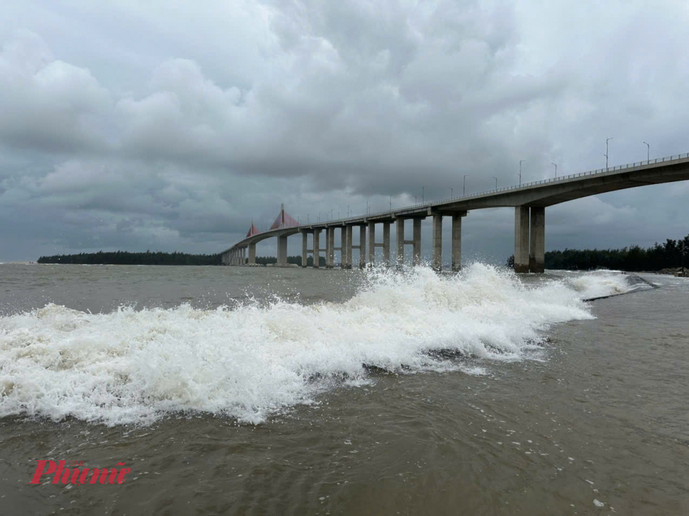 anh Phan Một, 35 tuổi, cho biết sóng biển cao, nước tràn qua đê chảy xiết. Cứ vài phút, sóng lớn cao hơn 3 m lại đánh vào bờ đê, người đi xe máy rất dễ ngã. 'Năm nào cũng vậy, khi nào sóng biển cao là nước biển lại tràn vào nhà dân. Sau trận lũ năm 1999, hàng trăm hộ dân đã phải di dời, tái định cư khi biển xâm thực', anh Một nói.