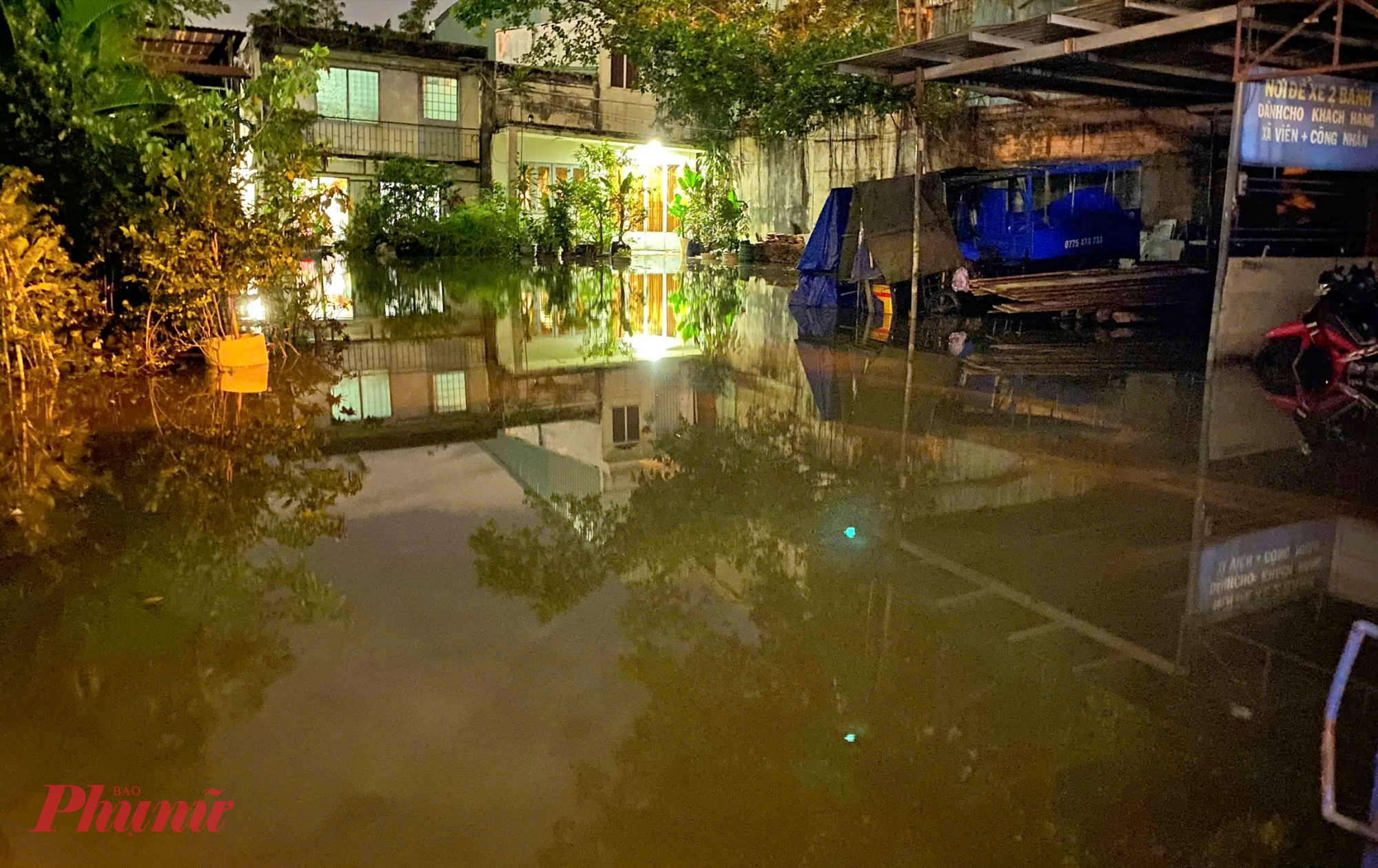 Một nhà dân trên đường Ung Văn Khiêm như bị cô lập do nước ngập kín sân phía trước.