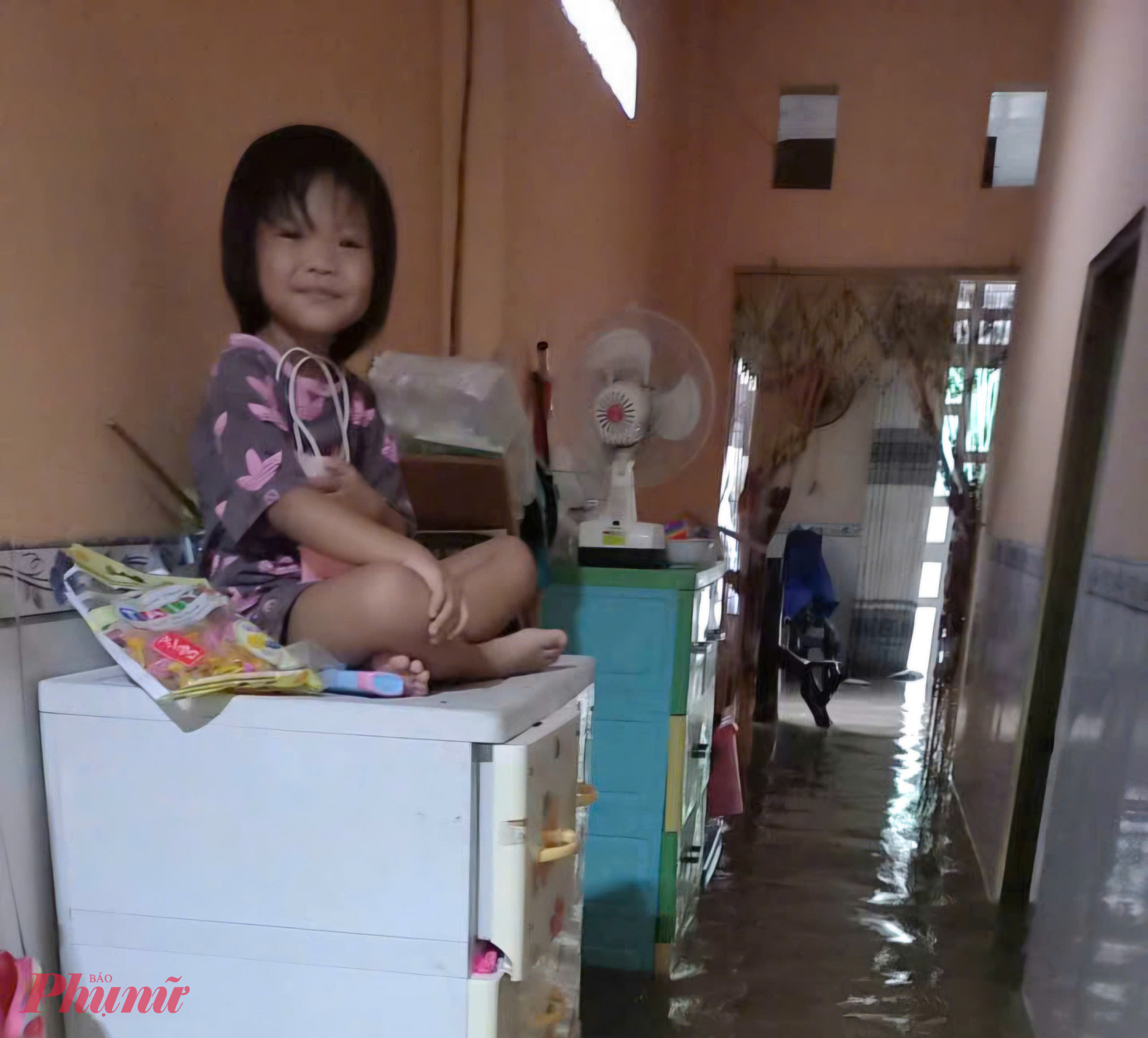 Một gia đình để em bé lên cao để tránh nước - Ảnh Trần Kiên