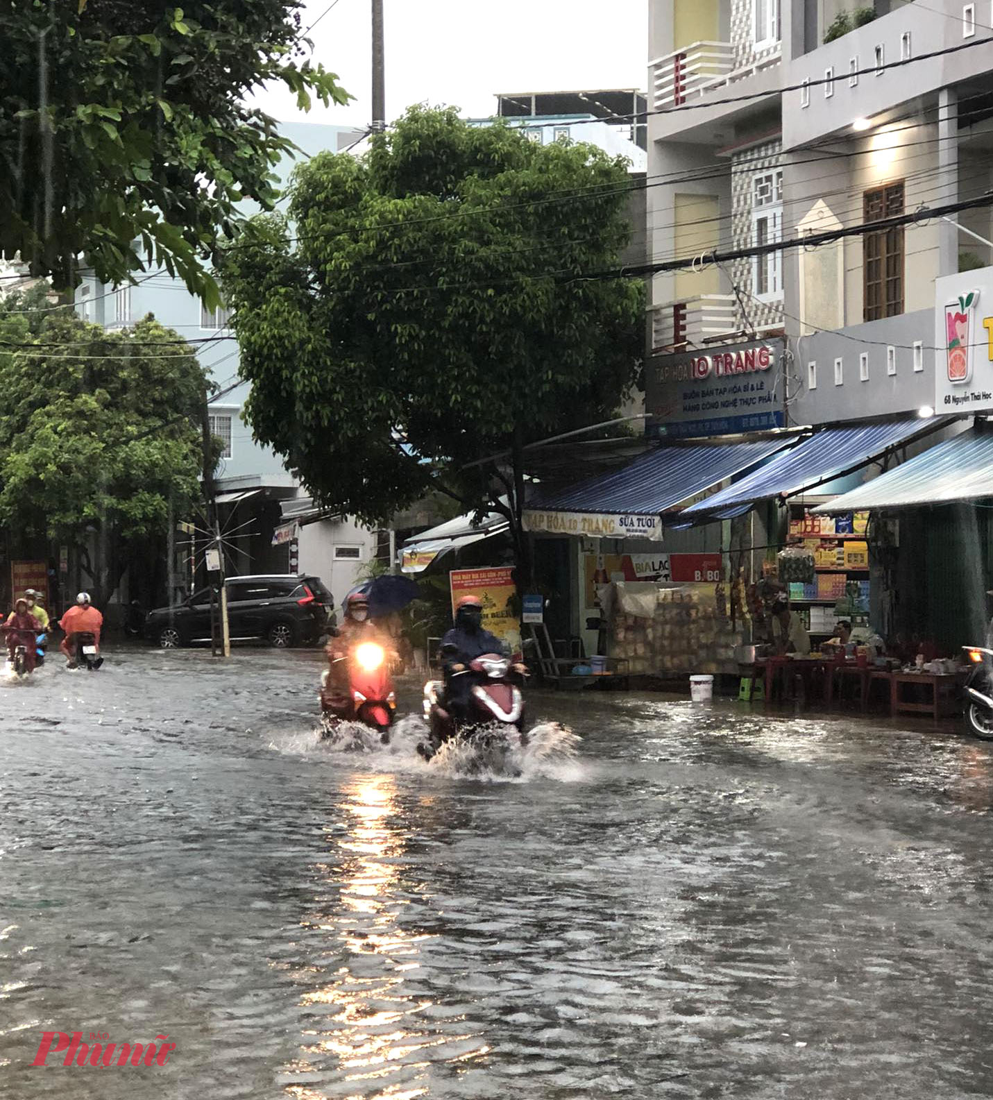 Rất nhiều người phải dắt xe lội bì bõm vì xe bị ngập nước, chết máy đường Nguyễn Tất Thành. Ảnh: NK