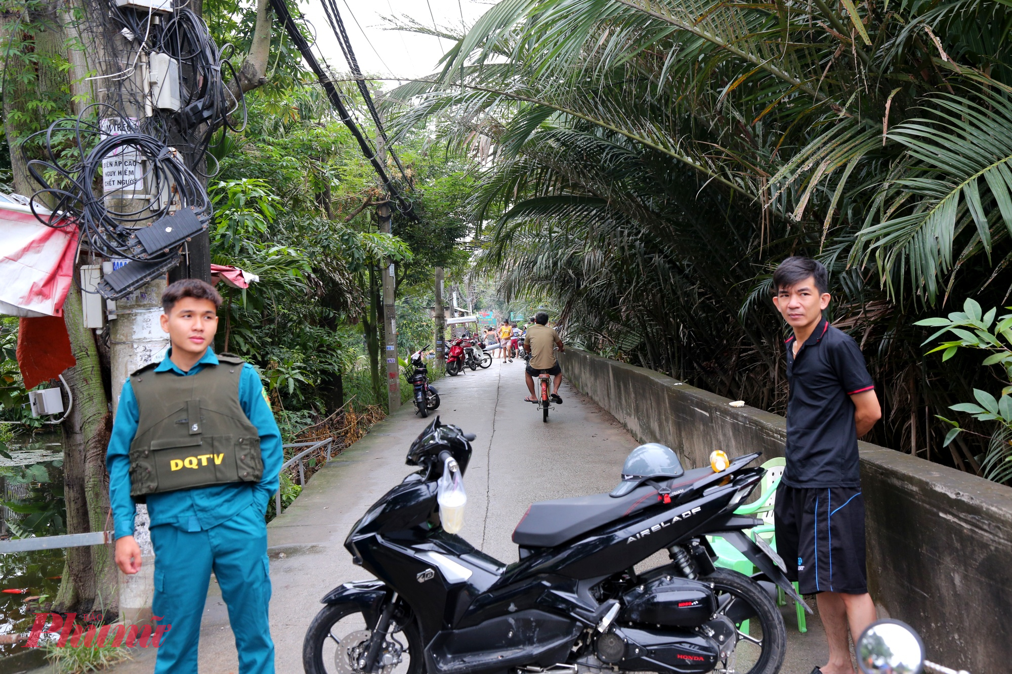 Lực lượng chức năng tạm thời chặn đường hẻm để thực hiện bơm nước từ khu dân cư nhà dân ra con rạch.