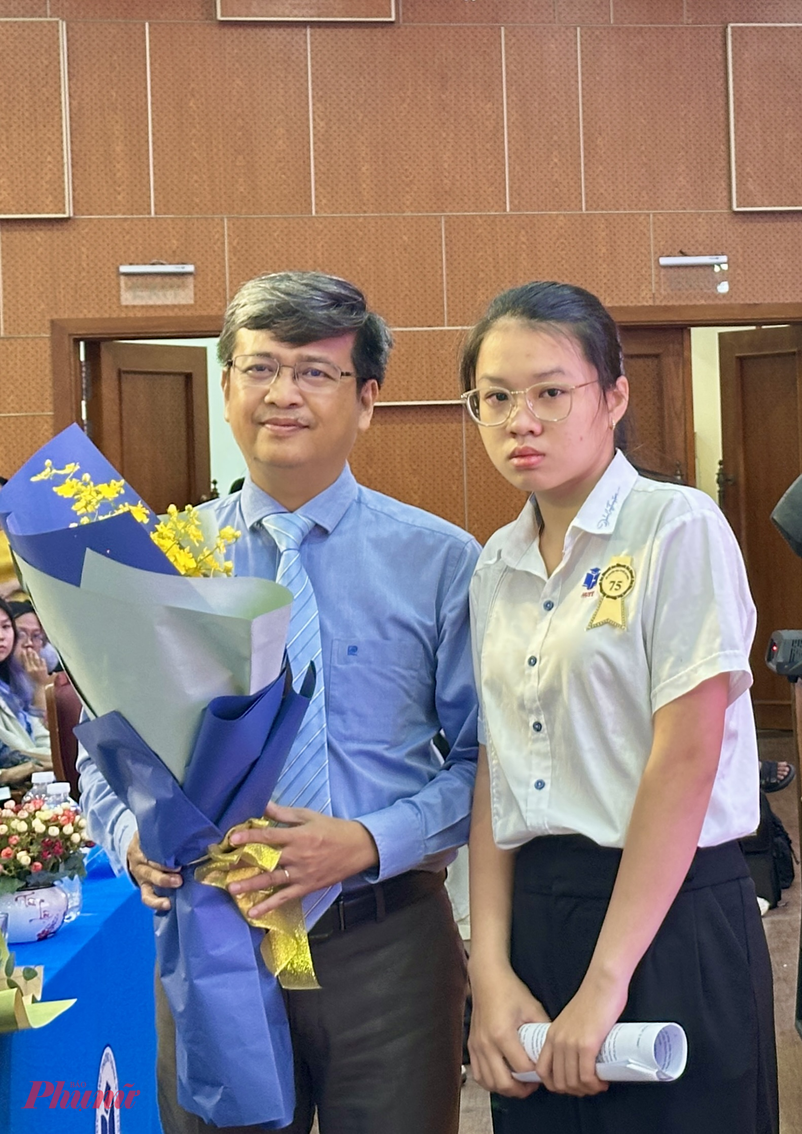 Gia Mỹ gửi hoa cám ơn tới đại diện Trường đại học Công Thương TPHCM - nơi em được nhận học bổng toàn khóa - Ảnh; Nguyễn Loan