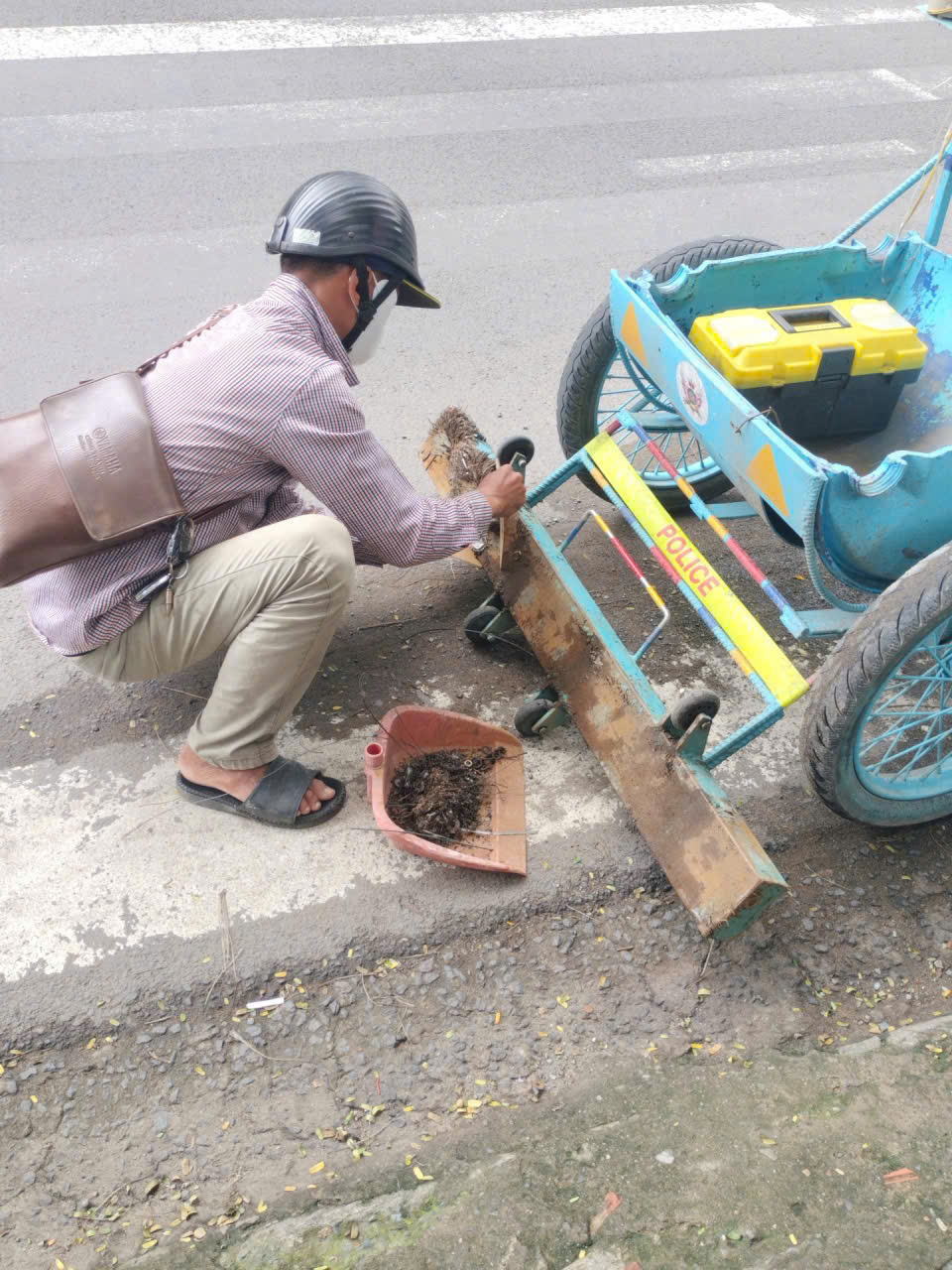 Người dân phối hợp với lực lượng chức năng hút đinh. Ảnh: CSGT