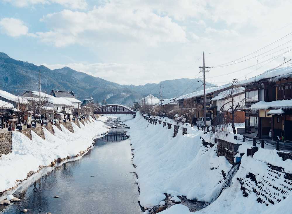 Từ cuối tháng 12 đến tháng 2, thị trấn cổ Hida Furukawa (tỉnh Gifu, Nhật Bản) khoác lên mình tấm áo tuyết trắng tinh khôi, mang đến khung cảnh nên thơ như bước ra từ truyện cổ tích. Dọc theo dòng sông Seto, những dãy nhà kho tường trắng cổ kính, con đường lát đá phủ tuyết dày, phản chiếu ánh sáng dịu của mùa đông – tất cả tạo nên một bức tranh mùa tuyết vừa tĩnh lặng, vừa tràn đầy sức sống.
