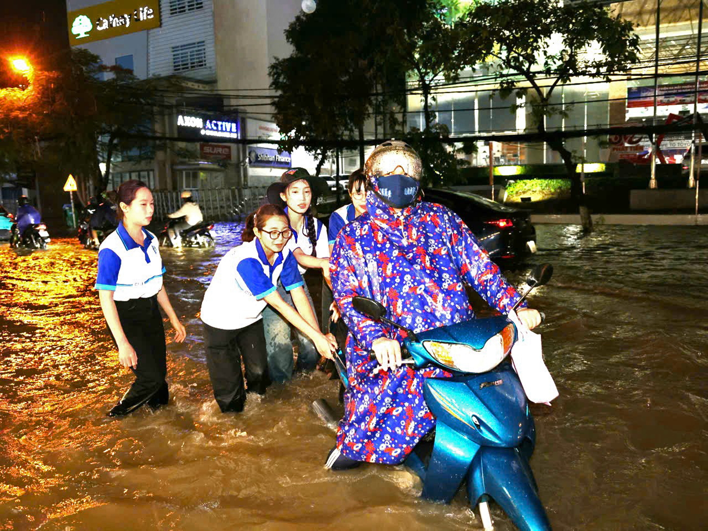 Triều cường gây thiệt hại nặng nề cho vùng Tây Nam Bộ Các nữ sinh viên ở TP Cần Thơ hỗ trợ người dân đi lại do bị ngập sâu bởi triều cường