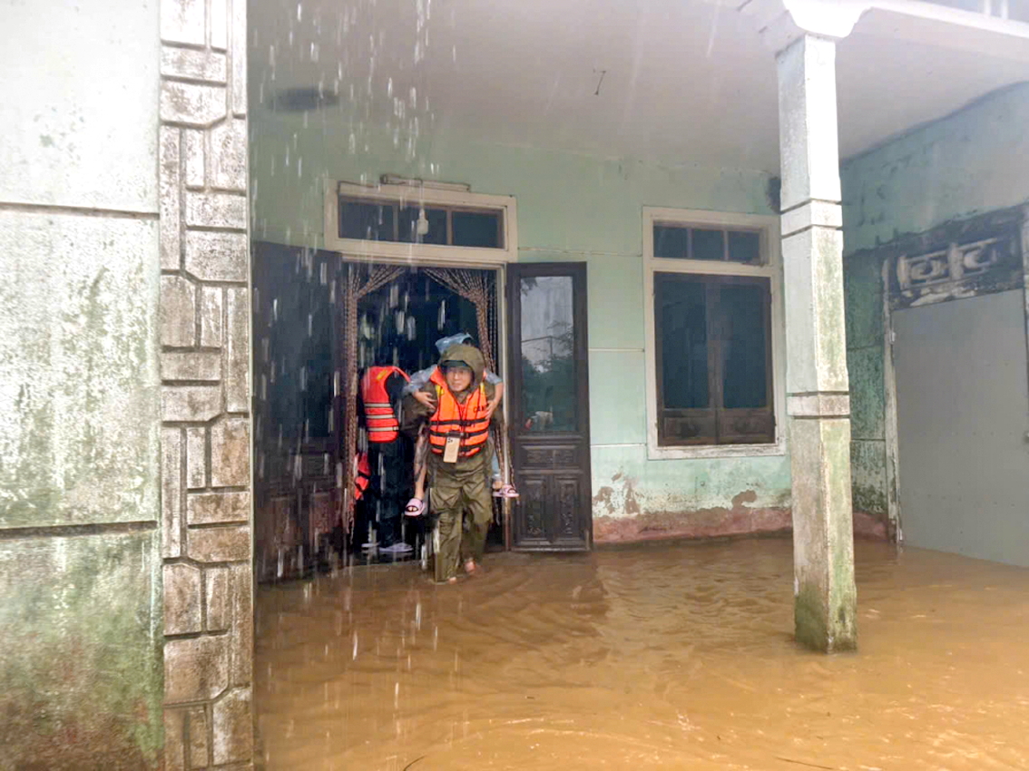 Công an xã Hưng Lộc (TP Huế) triển khai lực lượng di dời người già, trẻ em ra khỏi vùng ngập lũ - ẢNH: THUẬN HÓA 