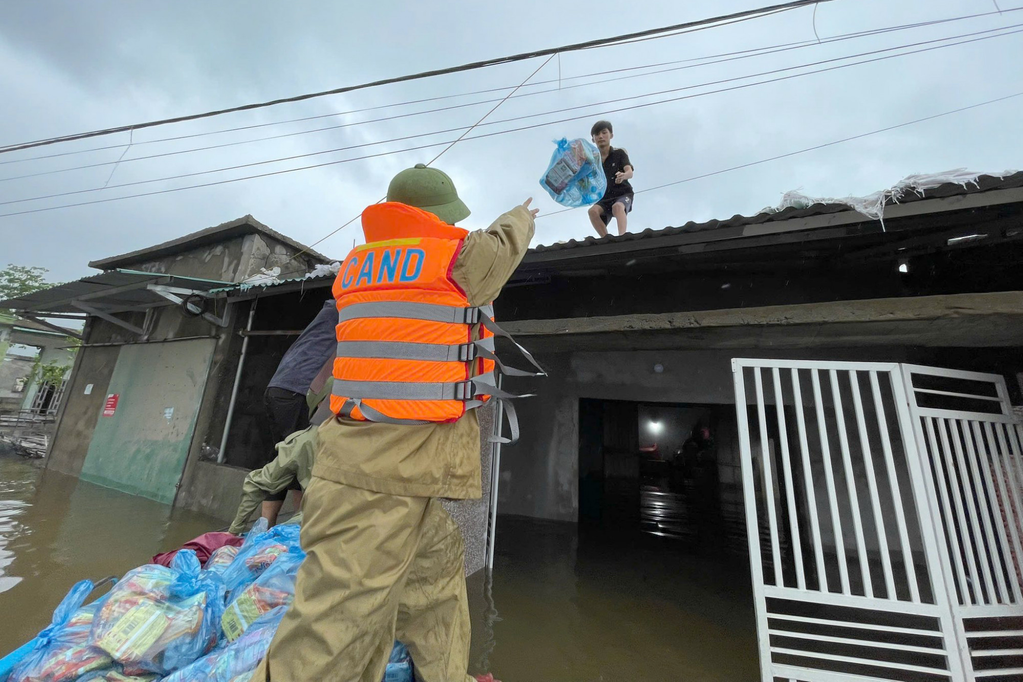 Công an phường Sông Trí tiếp tế nhu yếu phẩm cho người dân vùng ngập lụt - Ảnh: Khánh Trung