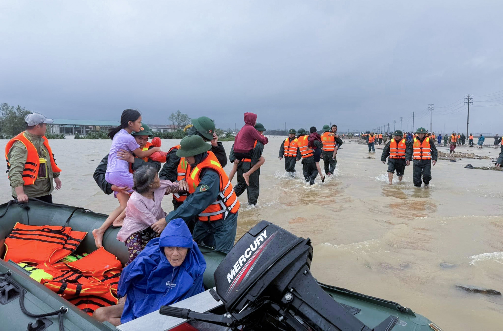 Lực lượng chức năng hỗ trợ người dân di dời đến nơi an toàn - Ảnh: Khánh Trung