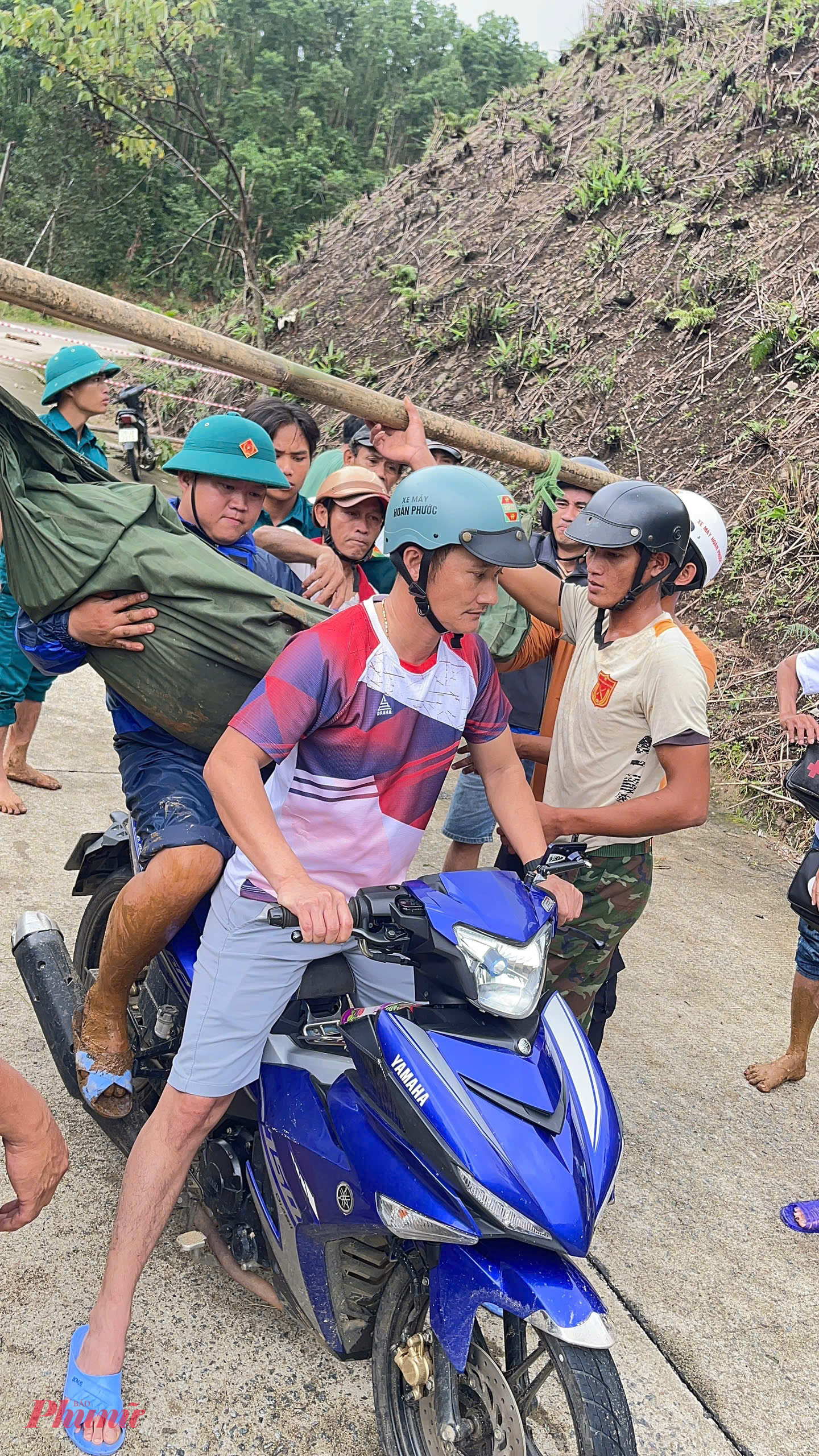 Quân và dân chung vai khẩn trương gánh người bị tai biến vượt núi đồi bị sạt lở để đưa xuống bệnh viện tỉnh kịp cấp cứu trong giờ vàng_Ảnh: D.X.