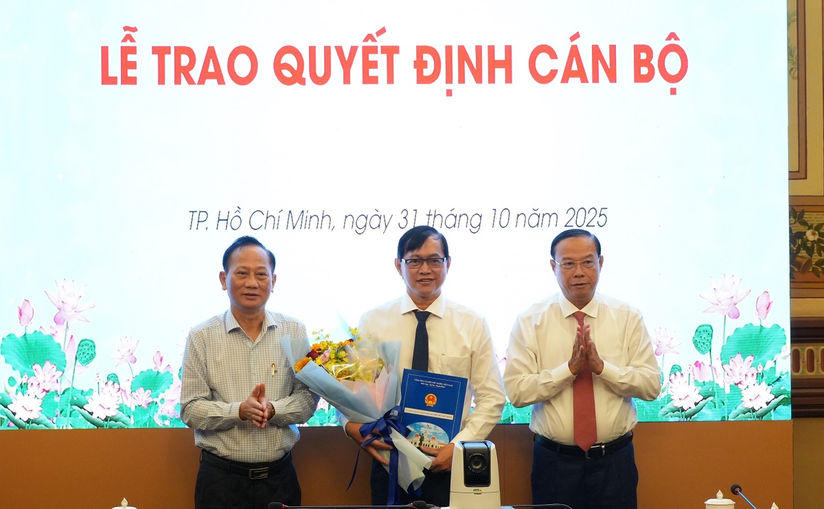 Phó Chủ tịch Thường trực UBND TPHCM Nguyễn Văn Thọ và Phó bí thư Đảng ủy UBND TPHCM Trần Văn Nam trao quyết định và tặng hoa chúc mừng ông Bùi Thanh Giang - Ảnh: Web UBND TPHCM