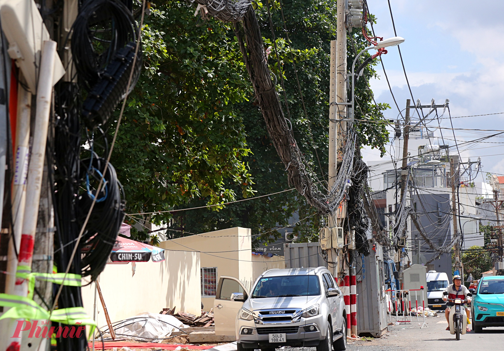 Dọc tuyến, hàng chục trụ điện vẫn nằm giữa lòng đường, chỉ cách làn xe chạy khoảng nửa mét. Vào giờ cao điểm, xe máy, ô tô phải lạng lách tránh trụ điện, nguy cơ xảy ra tai nạn. 