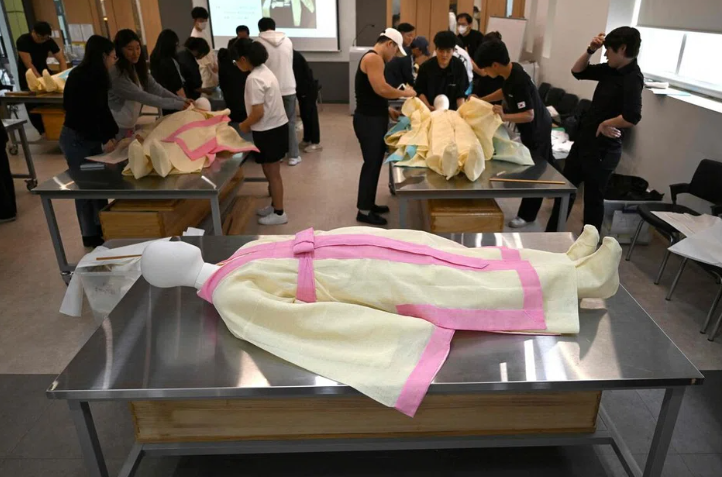 Các sinh viên mặc một ma-nơ-canh trong tấm vải tang lễ truyền thống của Hàn Quốc trong một lớp quản lý tang lễ tại Viện Khoa học và Công nghệ Busan vào ngày 24 tháng 9.  ẢNH: AFP