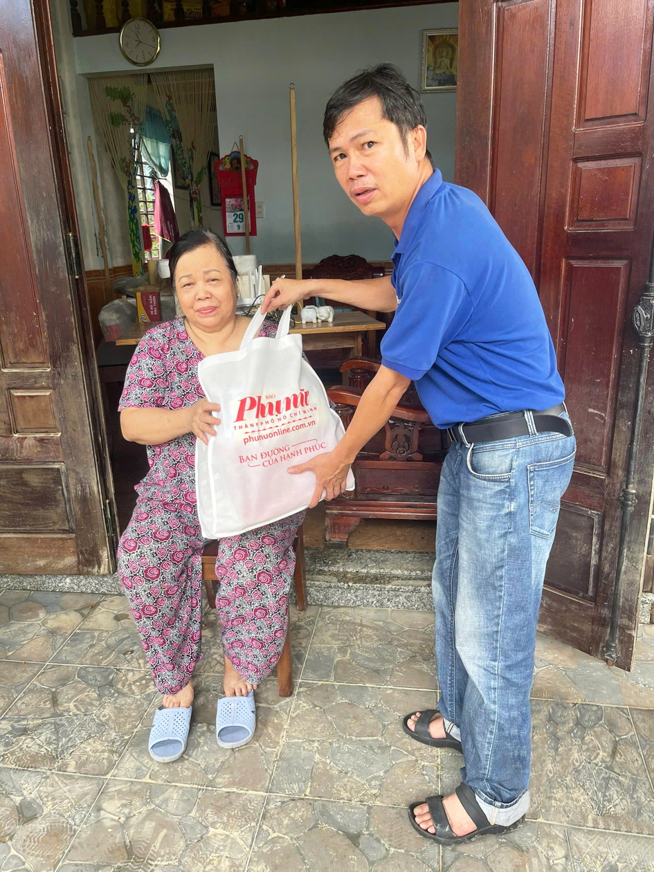 Đại diện Báo Phụ nữ TPHCM tặng quà cho người dân  ở làng Vân Dương, phường Vỹ Dạ, TP Huế - ẢNH: THUẬN HÓA