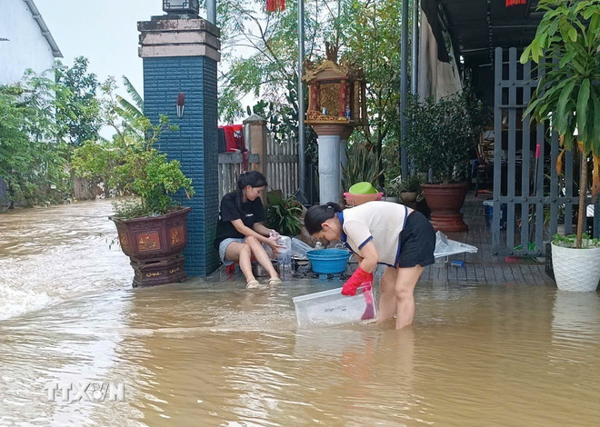Người dân Huế tất bật dọn dẹp nhà cửa sau lũ. (Ảnh: Hải Âu/TTXVN)