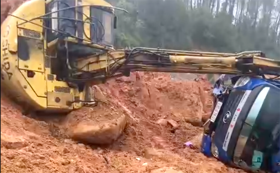 Máy múc và xe tải bị đất đá tràn xuống xô đổ khiến 2 người bị thương - Ảnh: Nguyễn Lương