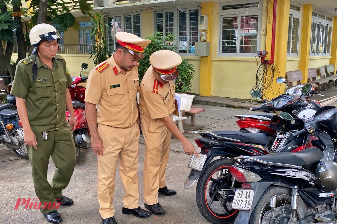 Lực lượng chức năng kiểm tra các xe máy tại bãi xe dành cho học sinh trong sân trường - Ảnh: TQ