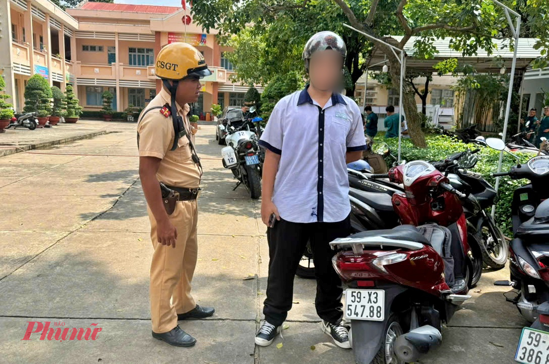 Một học sinh vừa chạy xe vào sân trường thì gặp CSGT - Ảnh: TQ.