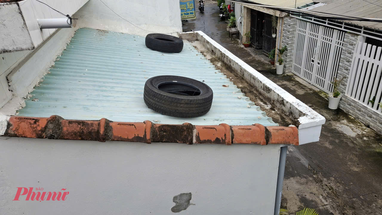 Người dân phường Tuy Hòa (Đắk Lắk) dùng lốp ô tô đè mái tôn phòng chống bão số 13 - Ảnh: Mạnh Trâm Trân
