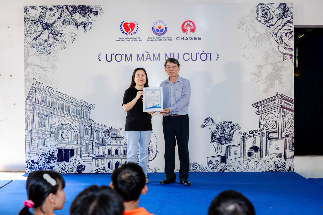 Ông Đỗ Trung Tín - Giám đốc Trung tâm Giáo dục nghề nghiệp cho Người khuyết tật và Trẻ mồ côi TPHCM trao thư cảm ơn đến đại diện nhà tài trợ CHAGEE Việt Nam - Ảnh: CHAGEE