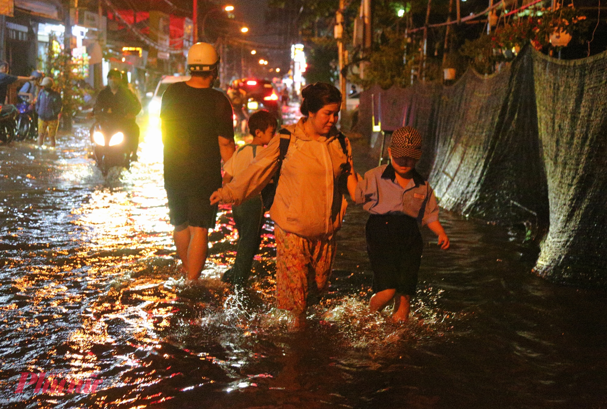 Nhiều trẻ em khổ sở lội nước ngập về nhà trong ngày triều cường 