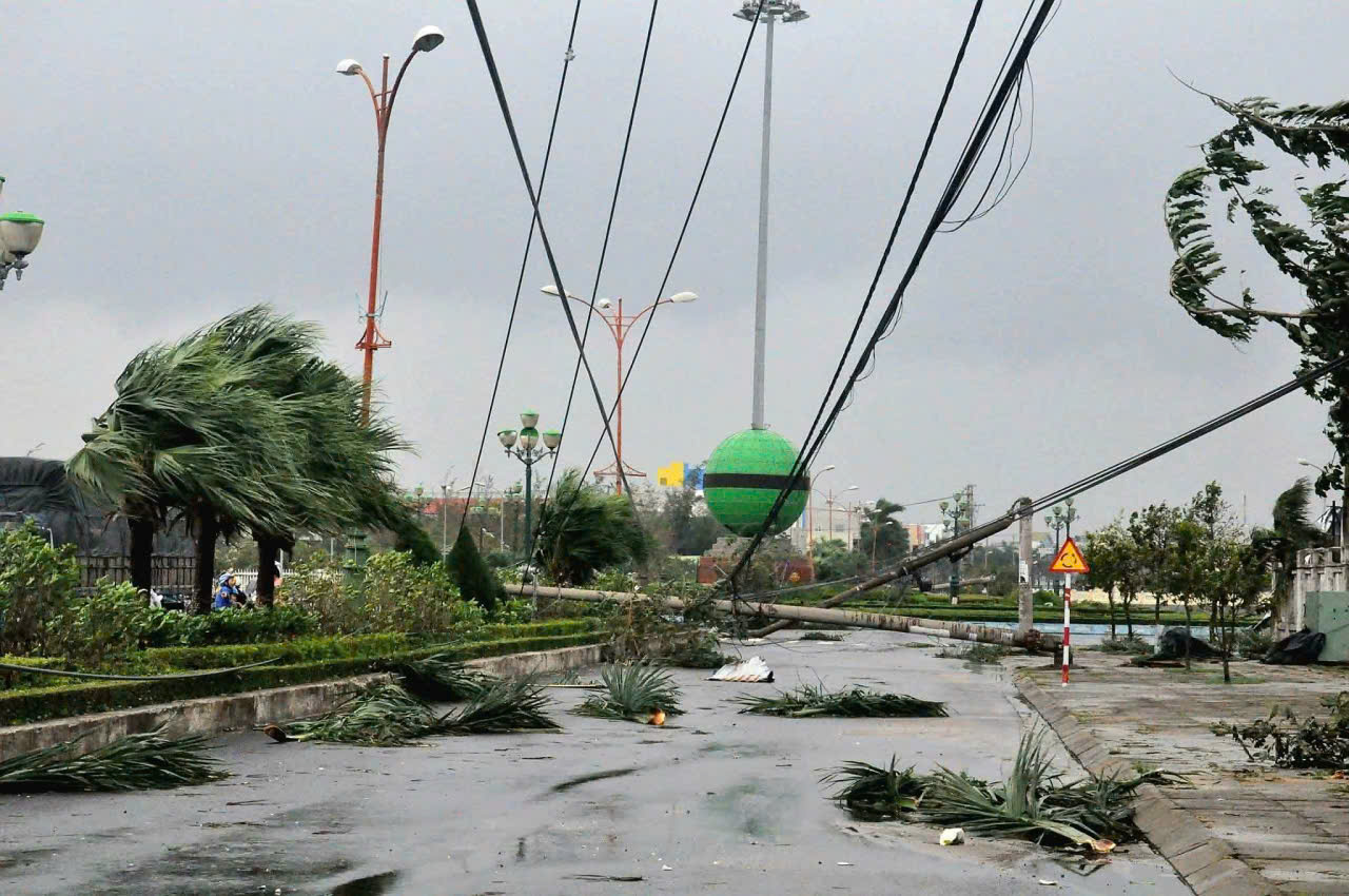 Cột điện ngã đổ kéo theo những nhiều dây điện thòng xuống đường - Ảnh: B.X.