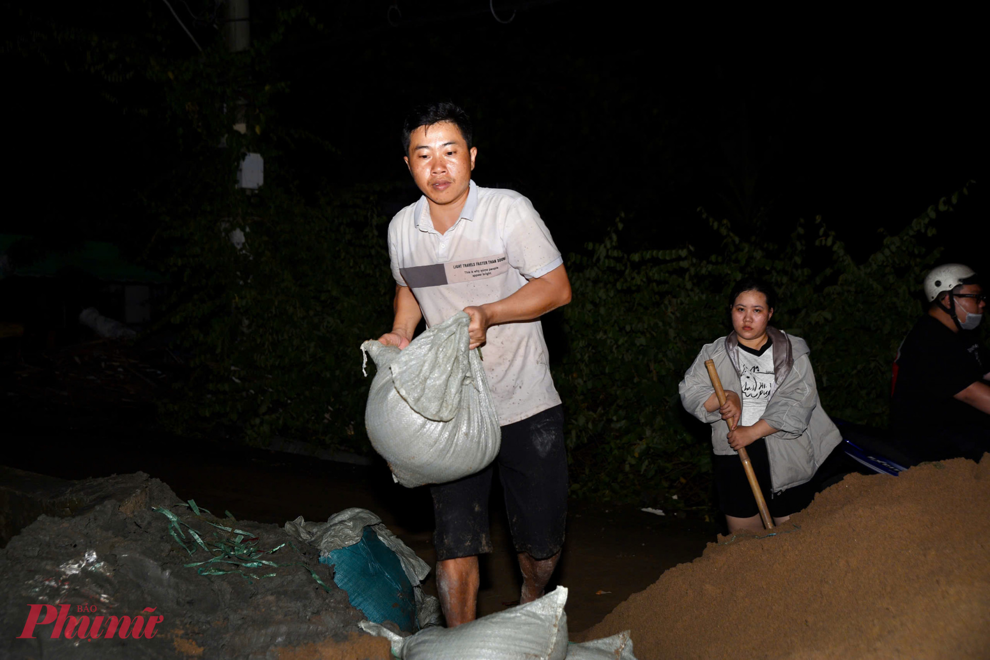 Người dân đắp bao cát xuyên đêm chống sạt lở tại khu vực bán đảo Thanh Đa - Ảnh: Thanh Tâm