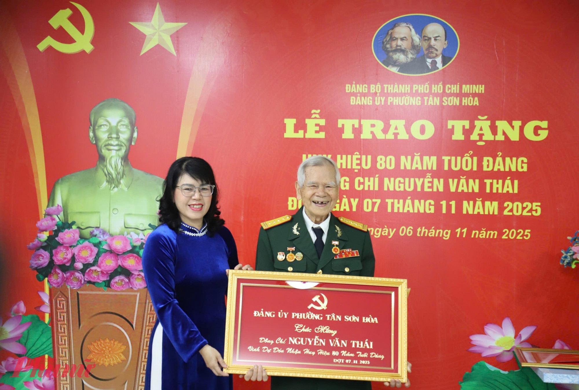 Bà Trương Lê Mỹ Ngọc - Bí thư Đảng ủy, Chủ tịch HĐND phường Tân Sơn Hoà tặng khánh vàng và hoa của Đảng ủy cho ông Nguyễn Văn Thái