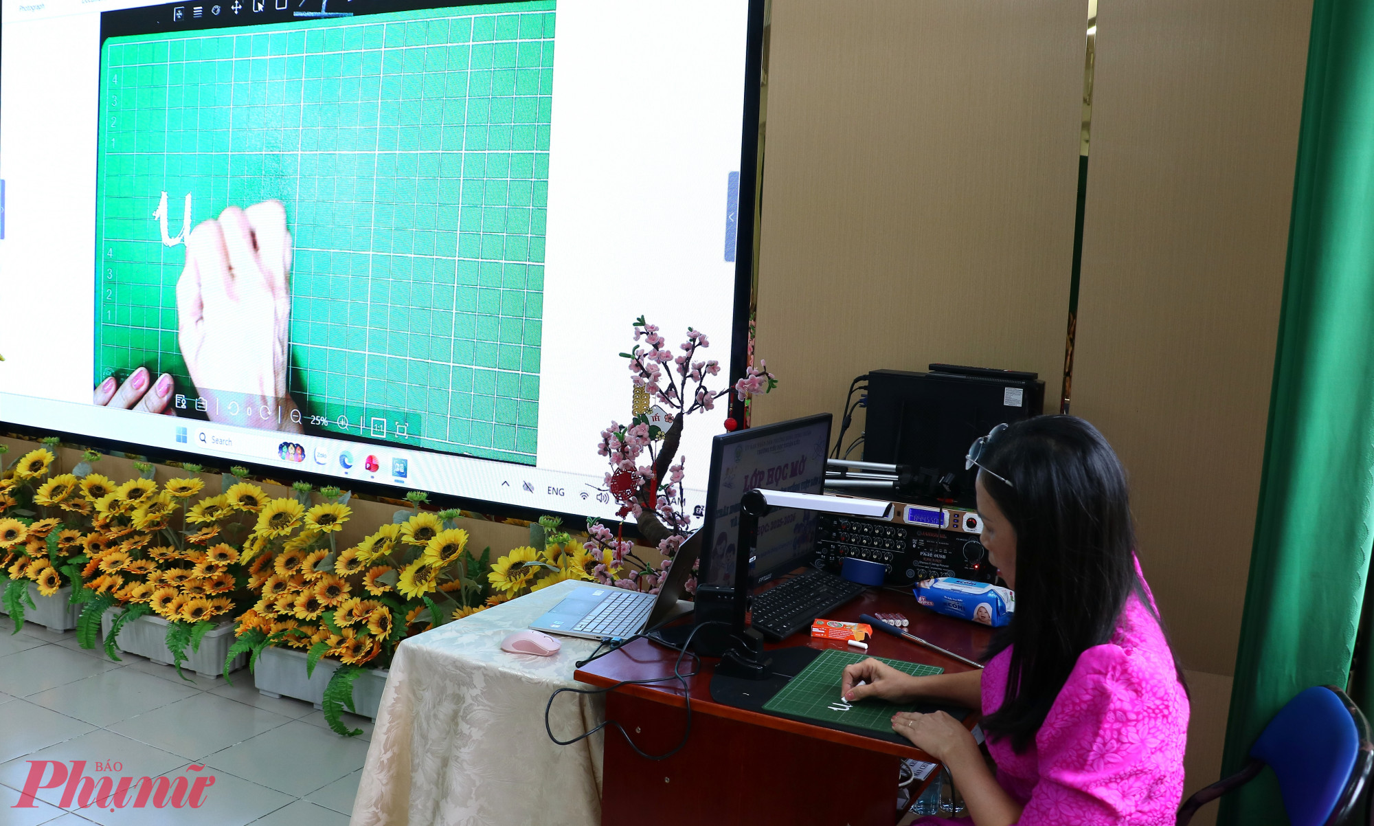 Cô Trân sử dụng máy soi để học sinh quan sát được từng nét chữ