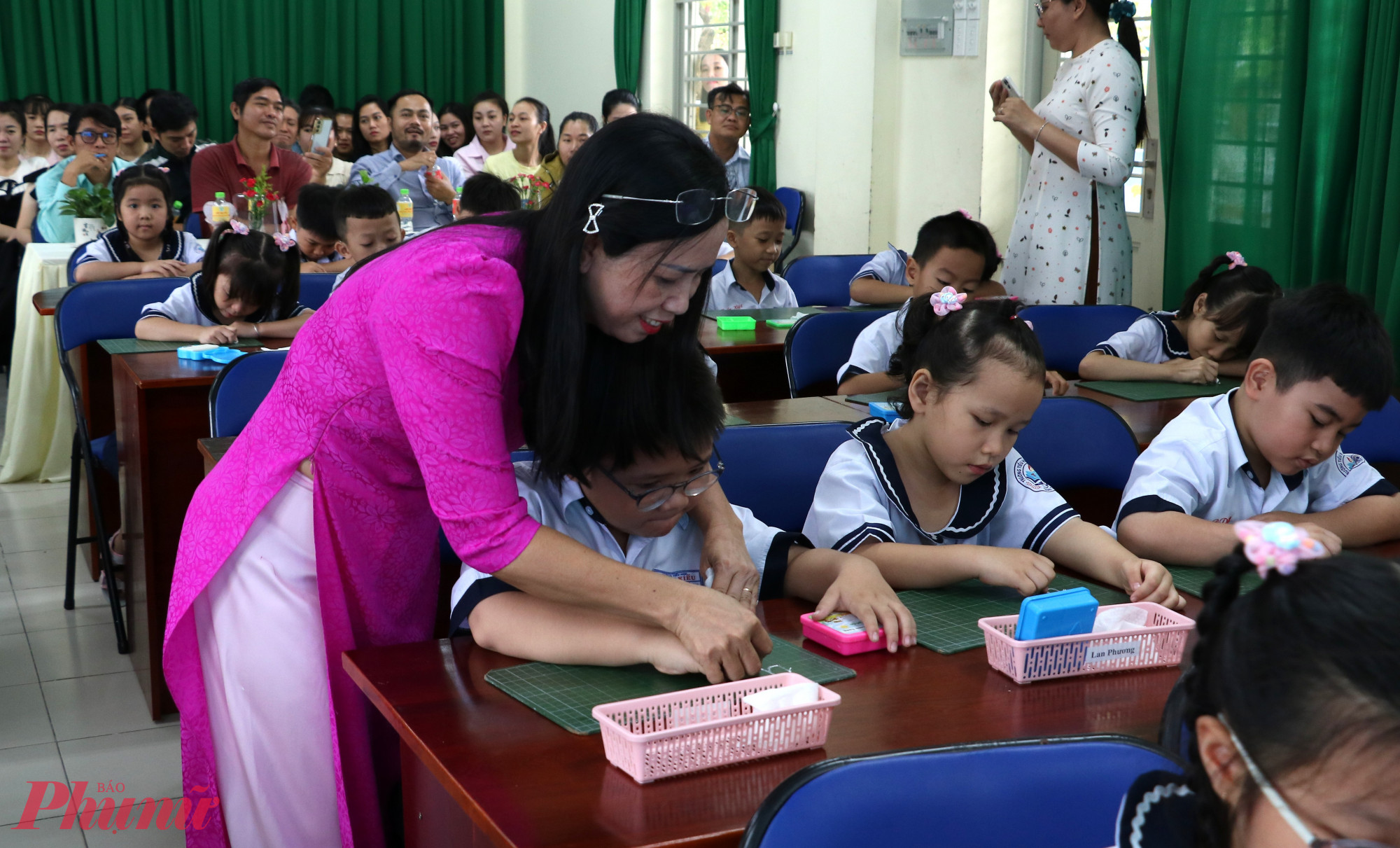 Cô Trân kèm một học sinh viết chữ