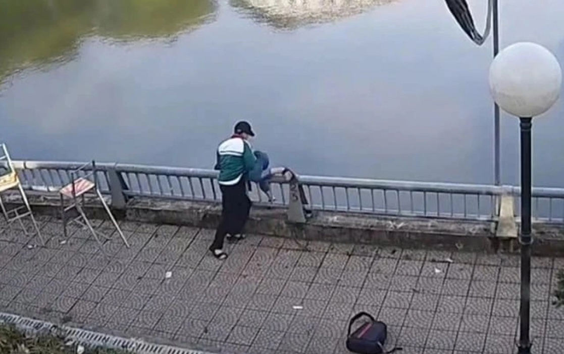 Hình ảnh nam sinh đánh bạn rồi bế, hất bạn của mình xuống hồ nước ở phường Yên Bái. (Ảnh: Cắt từ clip)