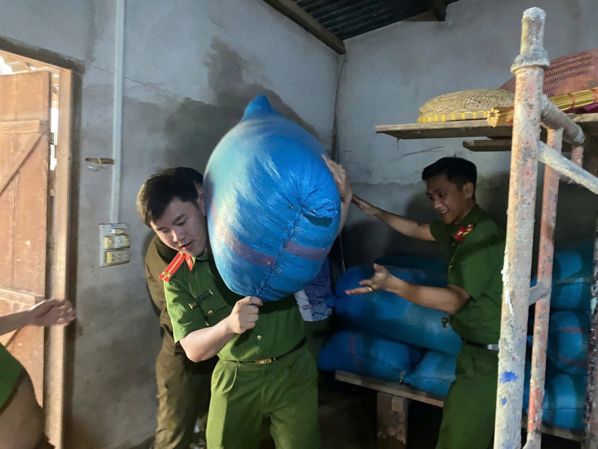 Lực lượng công an nỗ lực vận chuyển đồ đạc, tài sản cho người dân ra khỏi nơi ngập nước - Ảnh: H.V.