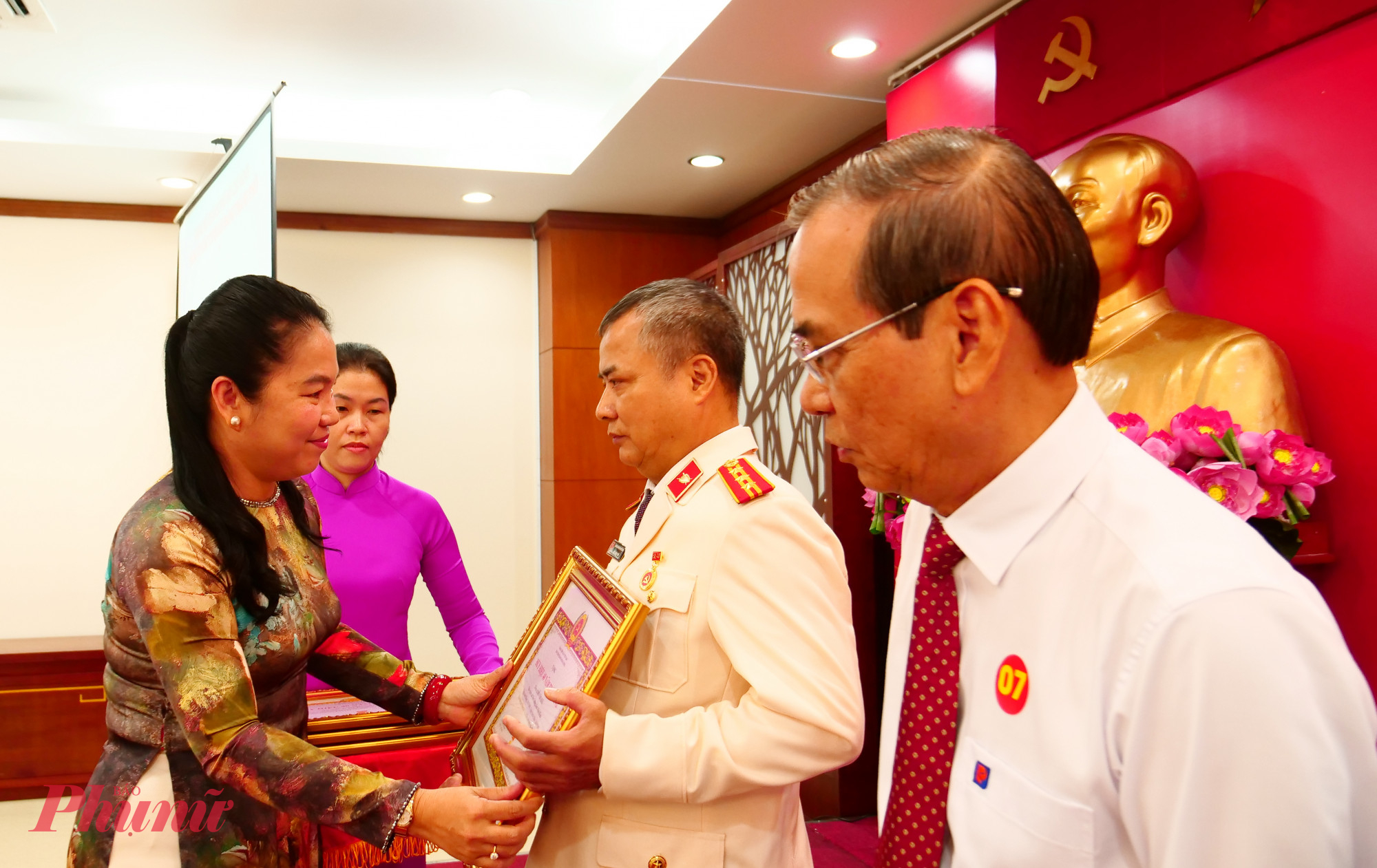 Bà Lê Thị Hồng Nga - Phó Bí thư Đảng ủy, Chủ nhiệm Ủy ban Kiểm tra Đảng ủy các cơ quan Đảng Thành phố - trao huy hiệu Đảng đến các đảng viên - Ảnh: Trang Nguyễn