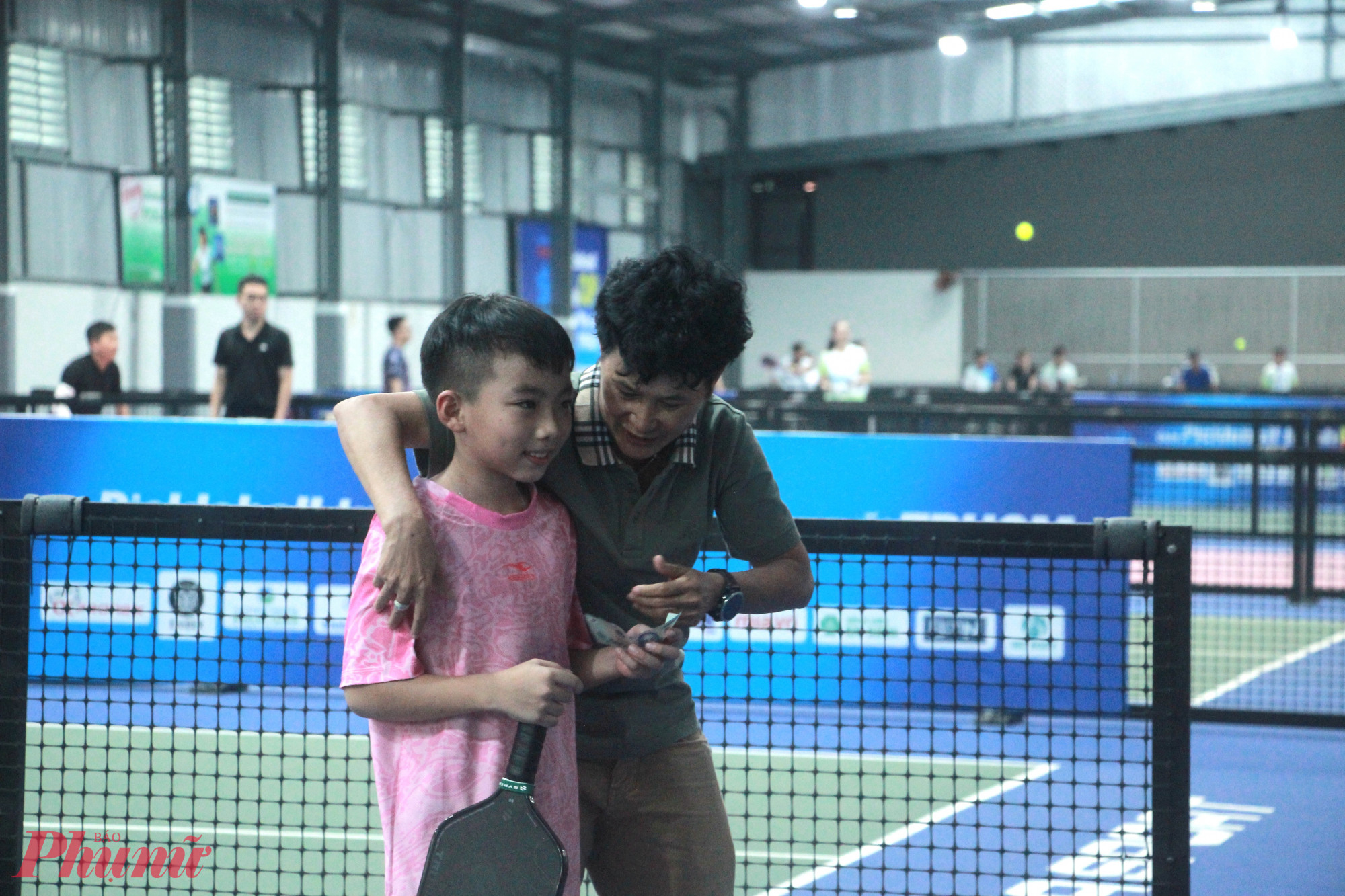 Bà Nguyễn Thị Kim Hồng  - HLV thủ môn đội tuyển nữ Việt Nam thưởng nóng ngay tại sân cho VĐV nhí Hữu Tài khi chứng kiến cậu bé thi đấu xuất sắc - Ảnh: Nguyễn Loan