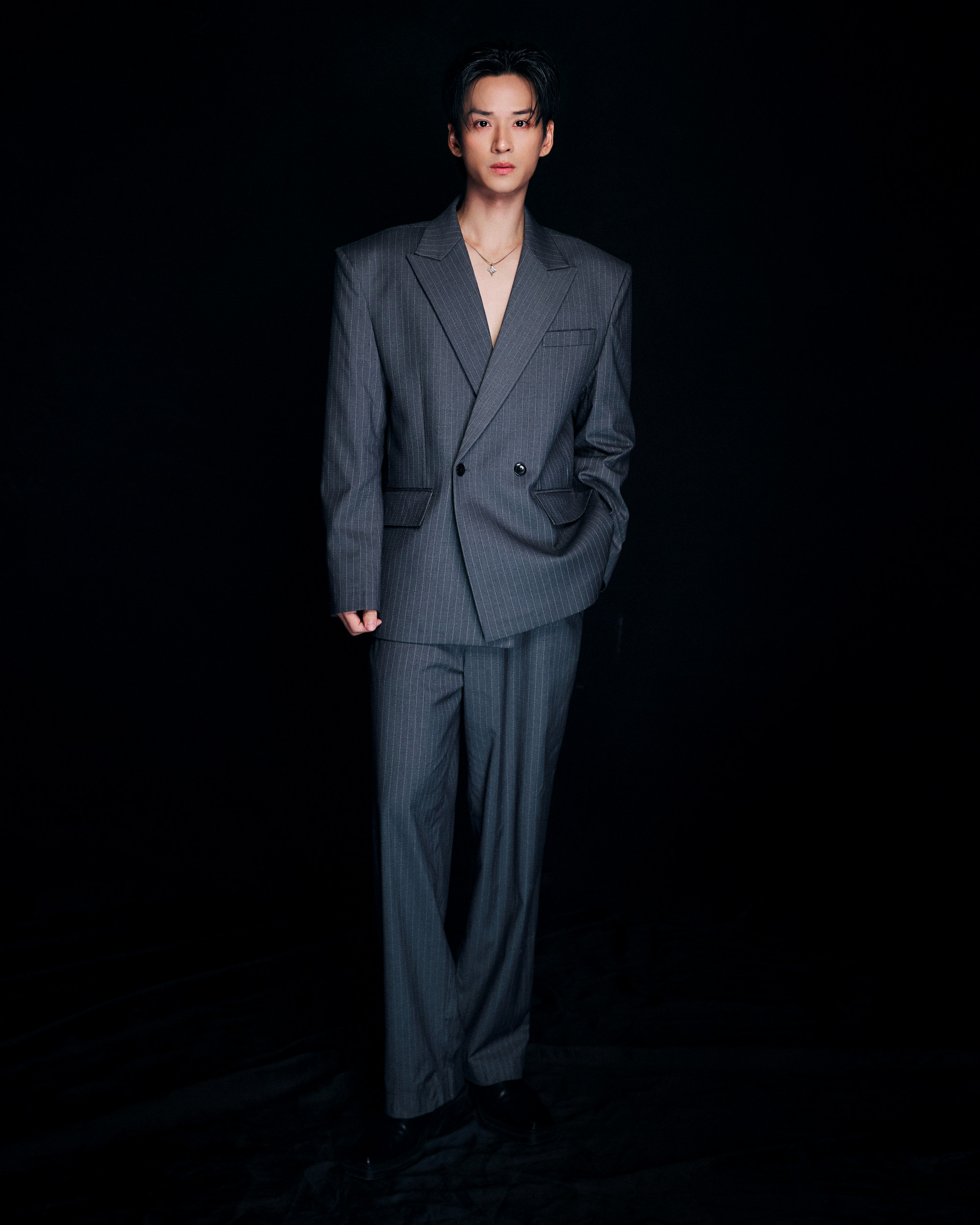 Nam diễn viên chọn bộ vest ghi xám họa tiết kẻ dọc, phần vai được cắt dựng mạnh mẽ giúp tôn dáng và tạo vẻ ngoài nam tính. Không bó buộc trong phong cách cổ điển, Trần Nghĩa khéo léo phá cách khi không cài hết khuy áo, kết hợp dây chuyền mảnh và kiểu tóc vuốt ngược, tôn lên gương mặt sáng và ánh nhìn tự tin.