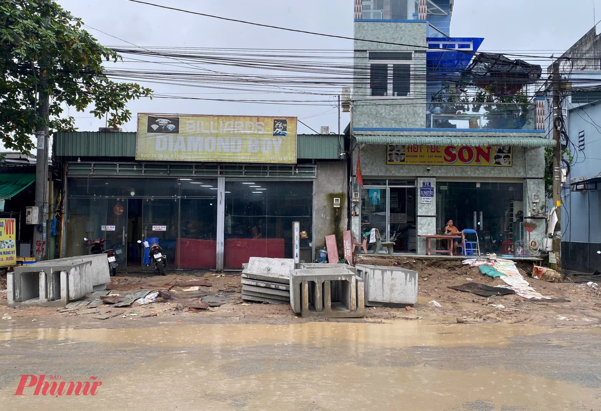 Hiện công trình ngổn ngang vật liệu xây dựng, lầy lội bùn đất đã gây ảnh hưởng không nhỏ đến đời sống, buôn bán của người dân hai bên đường. 