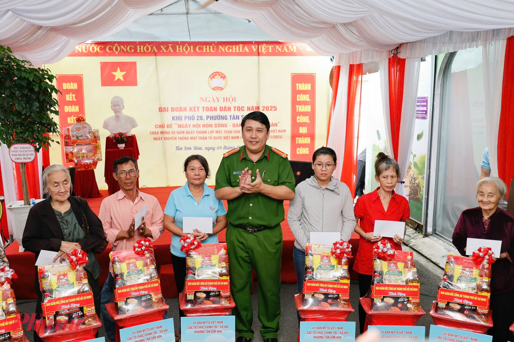 Ông Trần Trung Hiếu - Trưởng Công an phường Tân Sơn Hòa trao 27 phần quà của Ban Giám đốc Công an TPHCM tặng các hộ dân trên địa bàn, nhân Ngày hội Đại đoàn kết toàn dân tộc tại khu phố 28.