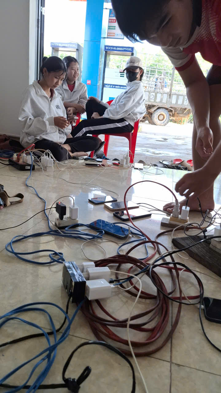 Người dân xã Xuân Phước sạt điện thoại tại cây xăng dầu chạy máy phát điện nhỏ- Ảnh: Mạnh Hoài Nam
