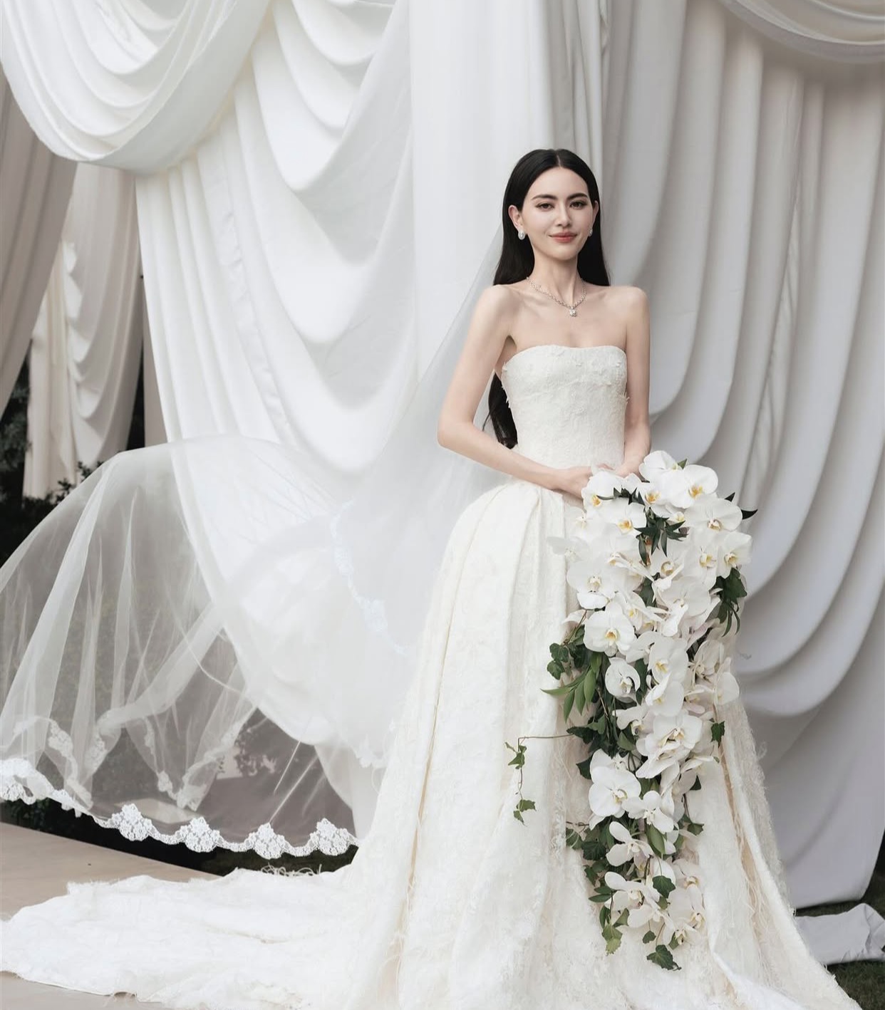 Phần thân váy xòe rộng, phủ ren và đính lông vũ nhẹ, mang đến vẻ mềm mại, lãng mạn nhưng vẫn giữ nét sang trọng cổ điển giúp cô dâu Mai Davika càng thêm gợi cảm.