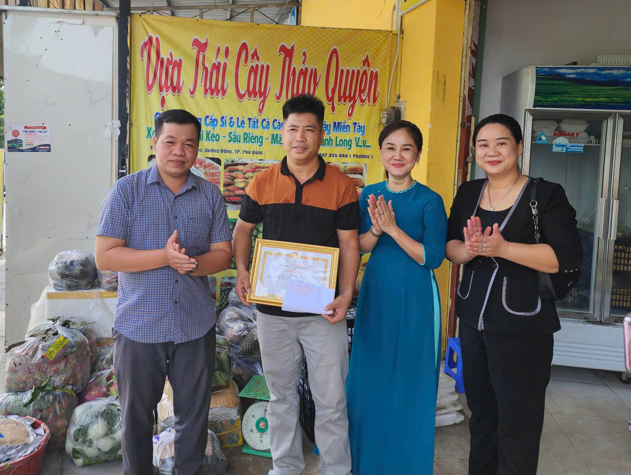 Bà Nguyễn Thị Kim Loan - Phó chủ tịch UBND đặc khu Phú Quốc tặng giấy khen cho anh Phương bán trái cây - Ảnh CTV