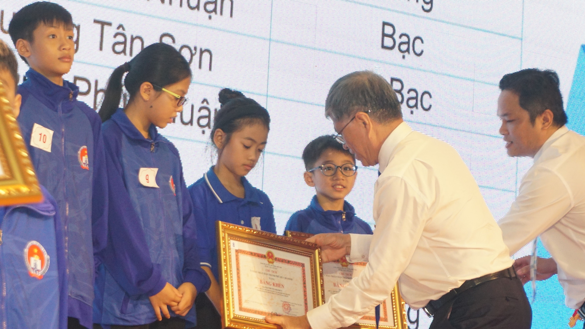 Ông Nguyễn Văn Hiếu - Giám đốc Sở GD-ĐT TPHCM - trao bằng khen cho học sinh - Ảnh: N.Q.