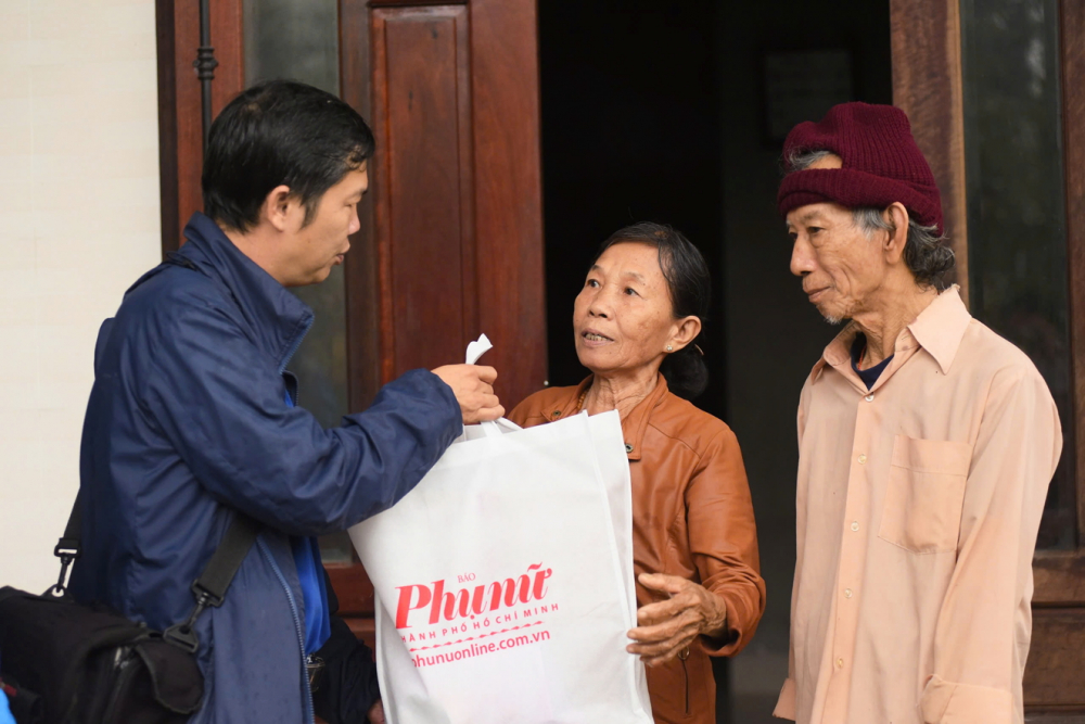 Đại diện Báo Phụ nữ TPHCM tặng quà cho gia đình bà Ngô Thị Dơi ở xã Quảng Điền, TP Huế - ẢNH: THUẬN HÓA