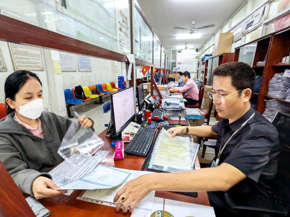 Cán bộ UBND phường Bảy Hiền, TPHCM hướng dẫn người dân làm thủ tục hành chính - ẢNH: THANH TÂM