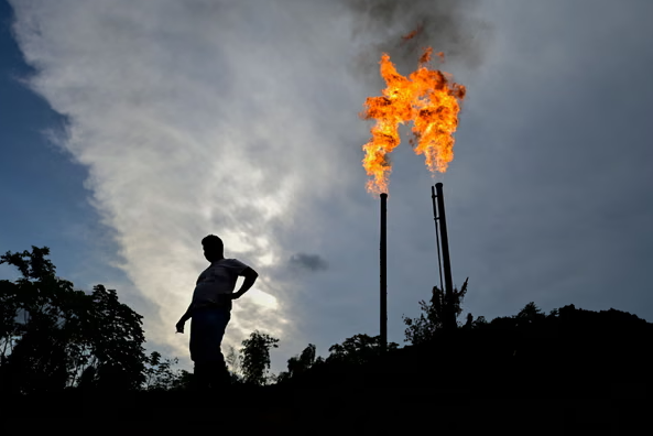 Nhà hoạt động người Ecuador Donald Moncayo Jiménez đứng bên cạnh pháo sáng khí đốt từ một nhà máy lọc dầu ở tỉnh Sucumbíos của Ecuador, vào ngày 14 tháng 1 năm 2023. Ảnh: Pedro Pardo / AFP / Getty Images