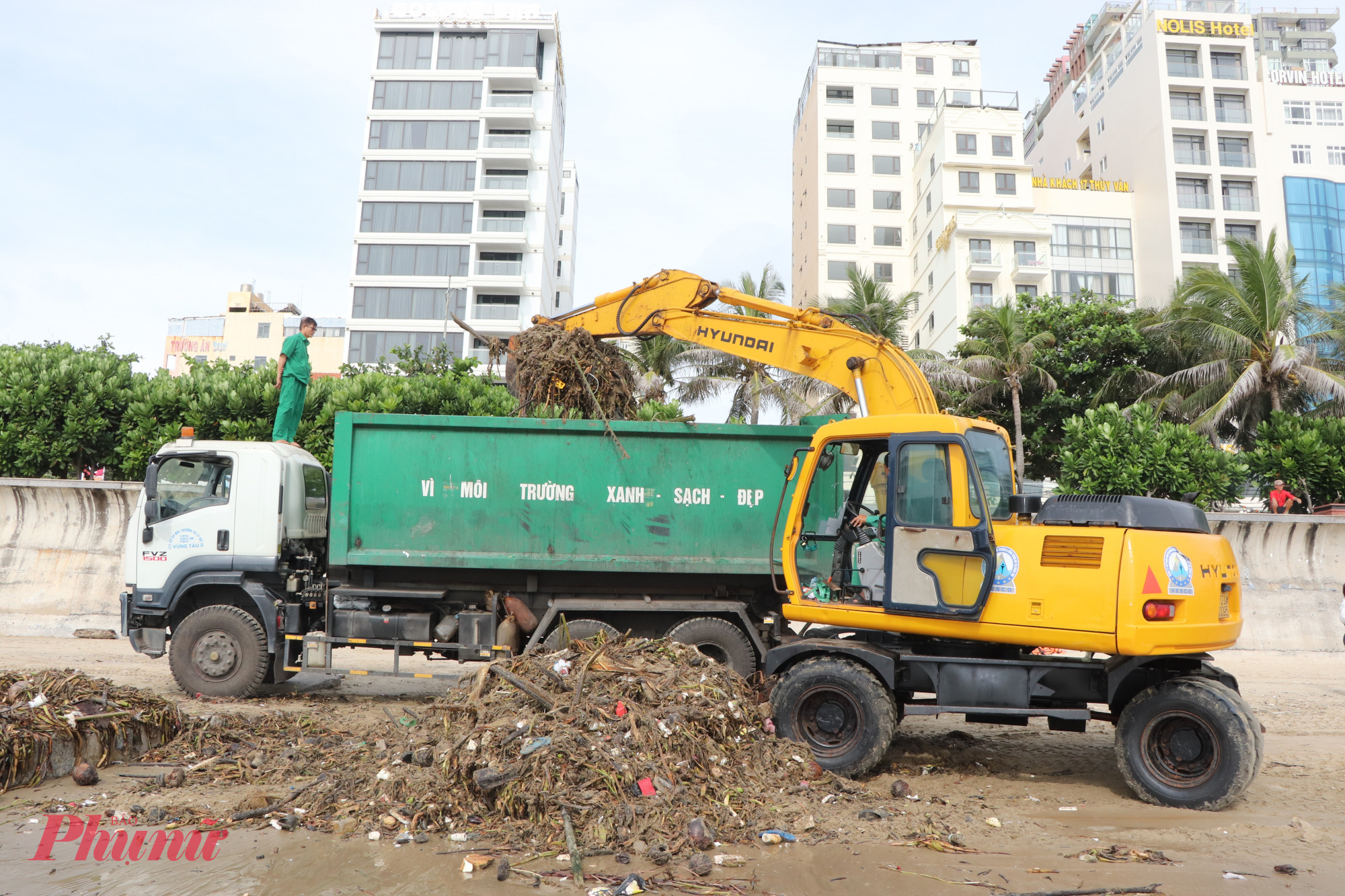 Xe cẩu xúc rác đại dương từ biển lên xe cuốn ép chuyên dụng để đưa đi xử lý. Ảnh: Tùng Lâm 