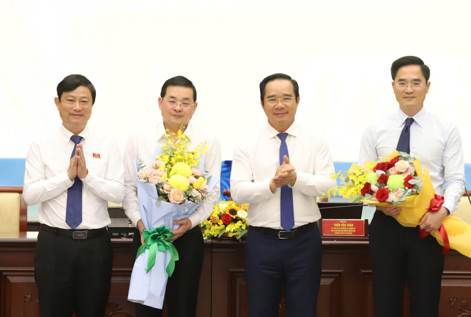 Chủ tịch UBND TPHCM Nguyễn Văn Được cùng Chủ tịch HĐND TPHCM Võ Văn Minh tặng hoa chúc mừng ông Trần Quang Lâm và ông Nguyễn Toàn Thắng - Ảnh: Thanh Tâm